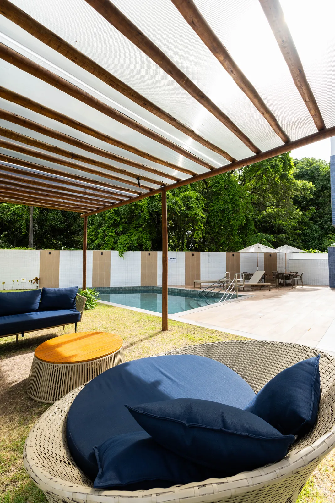 Piscina com pergolado e jardim