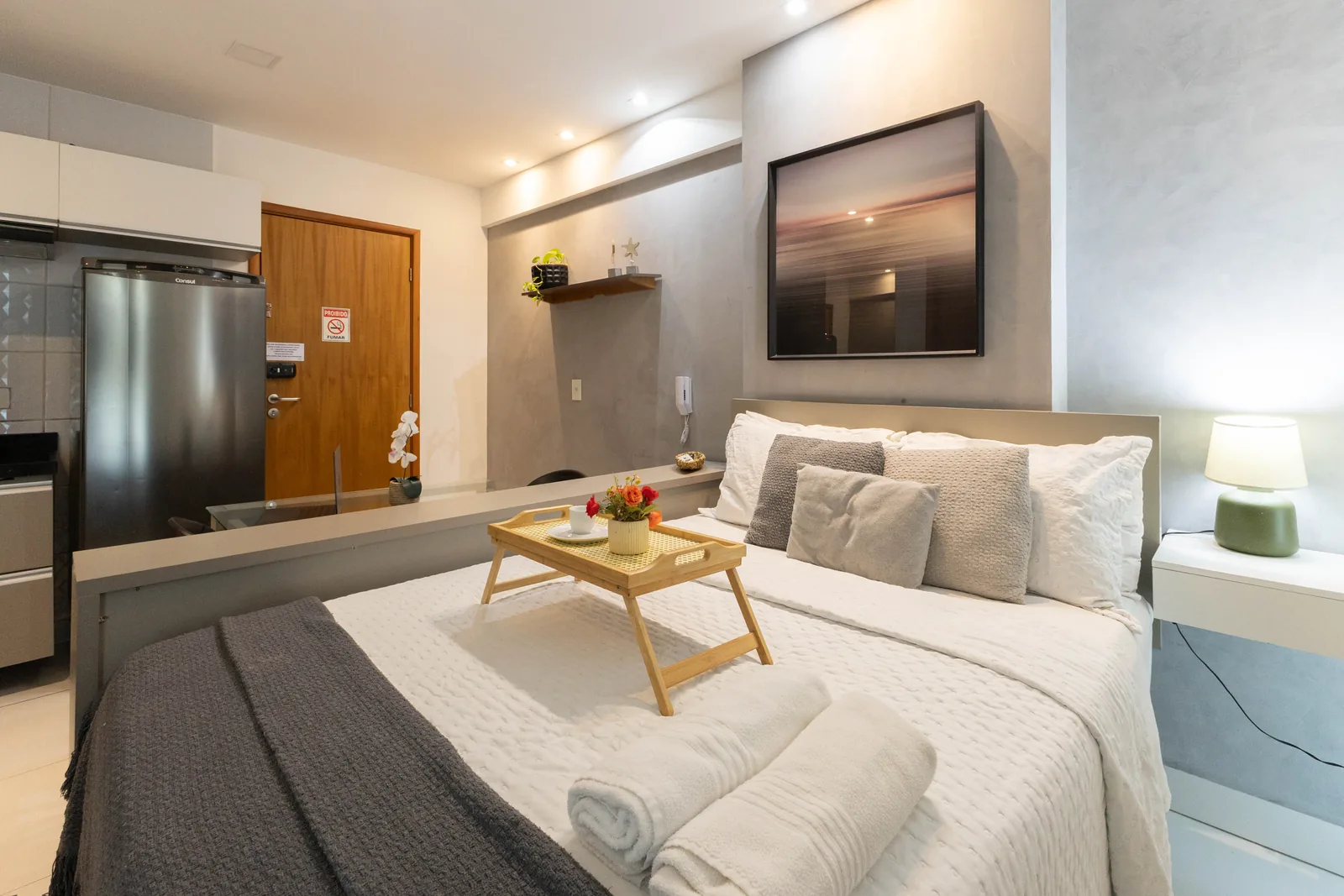 Ambiente com cama, TV e entrada